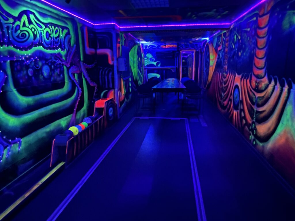 Blick über die Schwarzlicht-Kegelbahn mit 180°-Neon-Graffiti